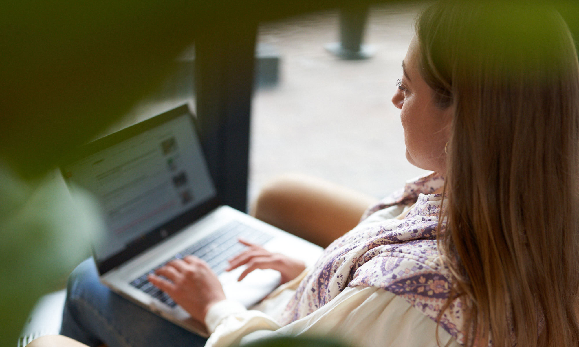 Kvinna sitter med en laptop i knät